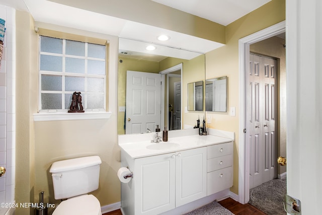 bathroom with hardwood / wood-style floors, vanity, and toilet