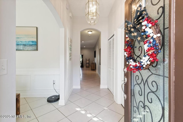 corridor with an inviting chandelier and light tile patterned flooring