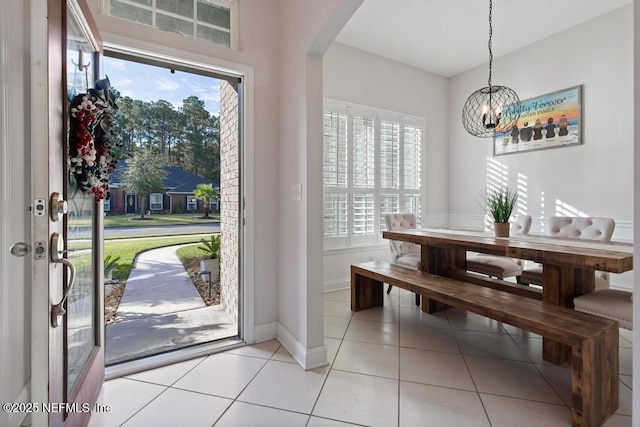 tiled dining room featuring an inviting chandelier