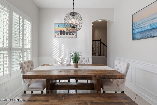 dining space featuring tile patterned flooring and an inviting chandelier