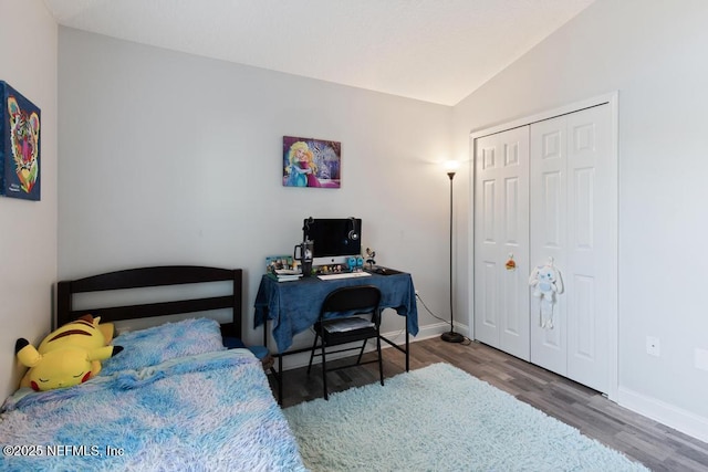 bedroom featuring wood-type flooring, a closet, and lofted ceiling