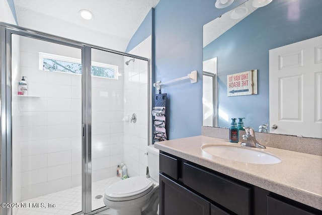 bathroom featuring a textured ceiling, lofted ceiling, toilet, vanity, and a shower with shower door