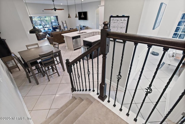 staircase featuring ceiling fan, tile patterned flooring, and sink