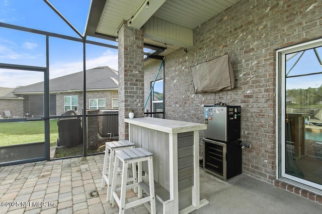 view of patio / terrace with a lanai and an outdoor bar