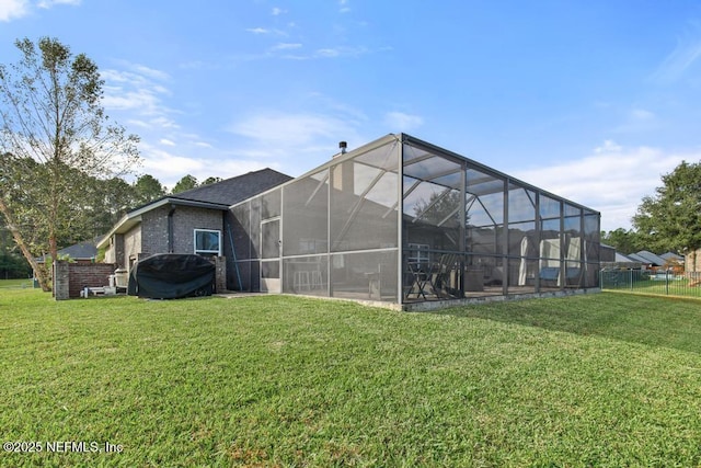 back of property with a lanai and a yard