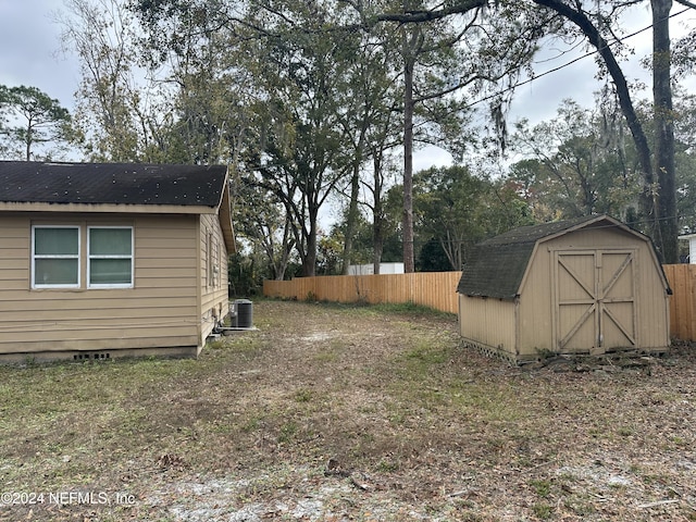 view of yard with central AC unit and a storage unit