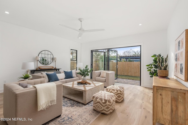 living room with light hardwood / wood-style flooring and ceiling fan