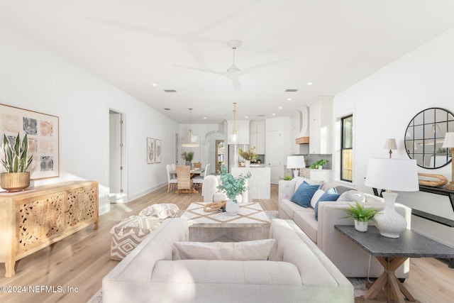 living room featuring ceiling fan and light hardwood / wood-style flooring