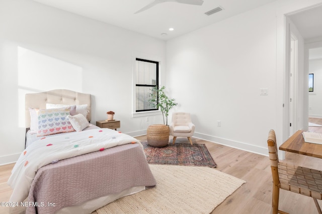 bedroom featuring ceiling fan, connected bathroom, and light hardwood / wood-style flooring