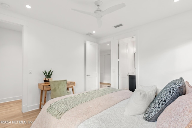 bedroom with ensuite bathroom, ceiling fan, and light hardwood / wood-style floors