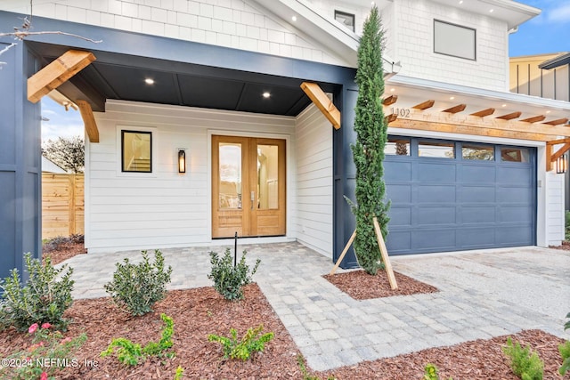 doorway to property with covered porch and a garage