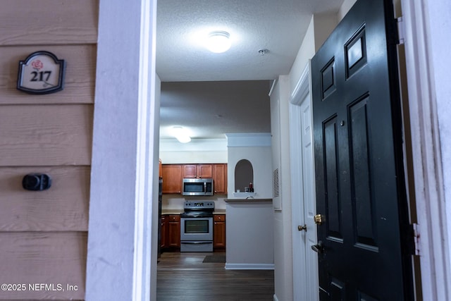 corridor with dark hardwood / wood-style flooring and a textured ceiling