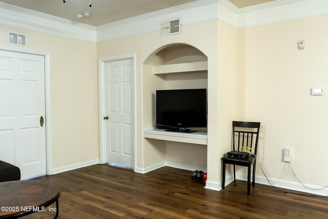 sitting room with built in shelves, ornamental molding, and dark wood-type flooring