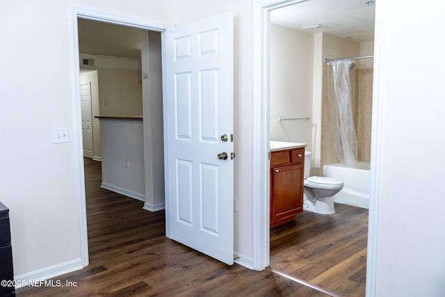 full bathroom with toilet, hardwood / wood-style floors, vanity, and shower / tub combo with curtain