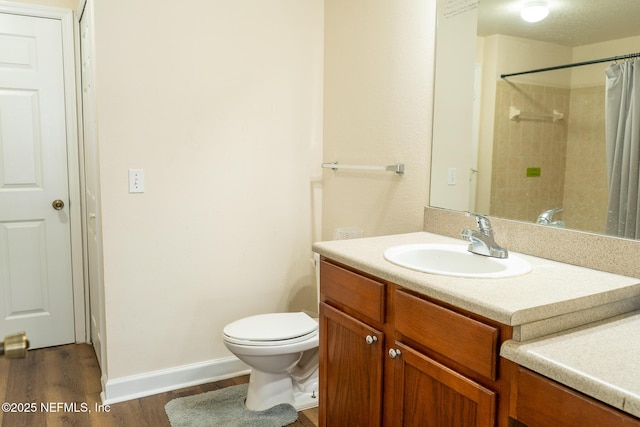 bathroom with hardwood / wood-style floors, vanity, a shower with shower curtain, and toilet