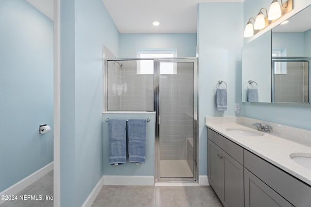 bathroom featuring tile patterned floors, vanity, and a shower with door