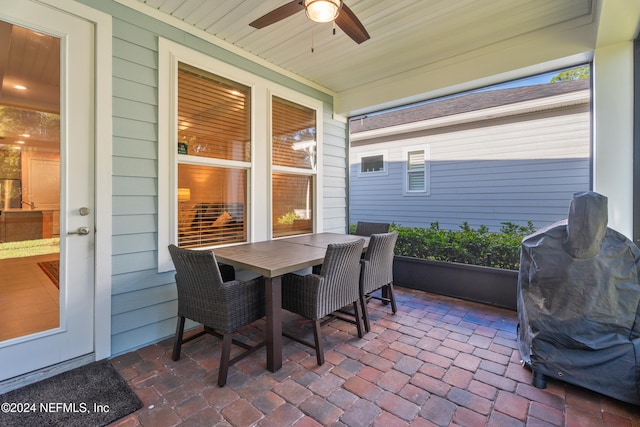 sunroom featuring ceiling fan and wood ceiling