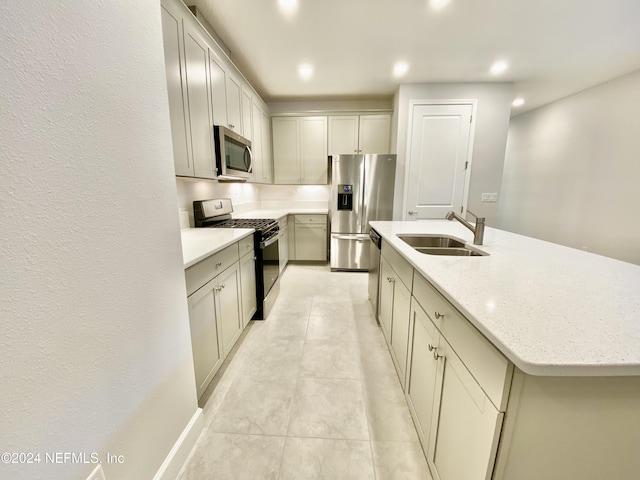 kitchen featuring light stone counters, stainless steel appliances, a kitchen island with sink, sink, and light tile patterned floors