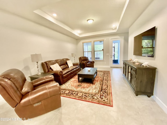 living room featuring light tile patterned floors and a tray ceiling