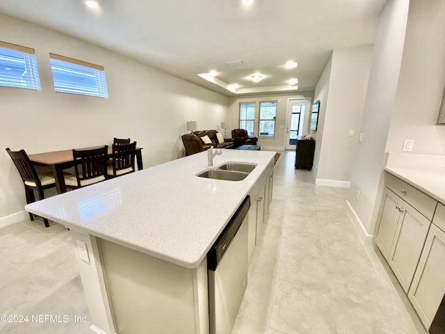 kitchen featuring dishwasher, a center island with sink, light stone counters, and sink