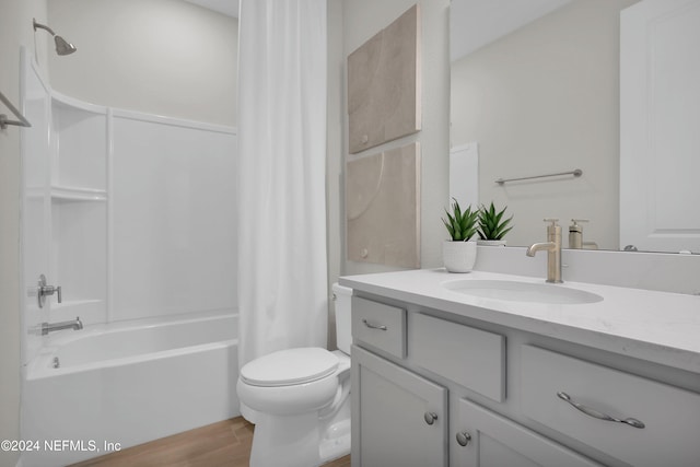 full bathroom with wood-type flooring, vanity, shower / tub combo, and toilet