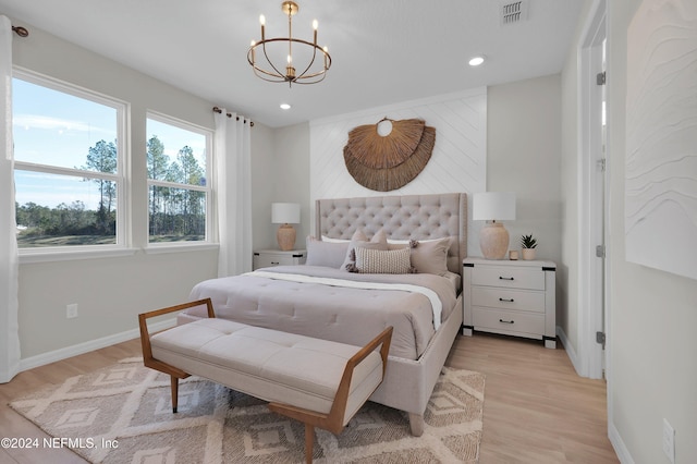 bedroom with light hardwood / wood-style flooring and a chandelier