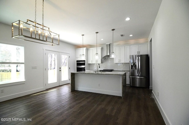 kitchen featuring a kitchen island with sink, stainless steel fridge with ice dispenser, wall chimney range hood, and white cabinetry