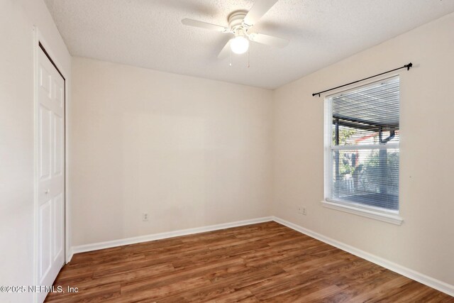 spare room with ceiling fan, dark hardwood / wood-style flooring, and a textured ceiling