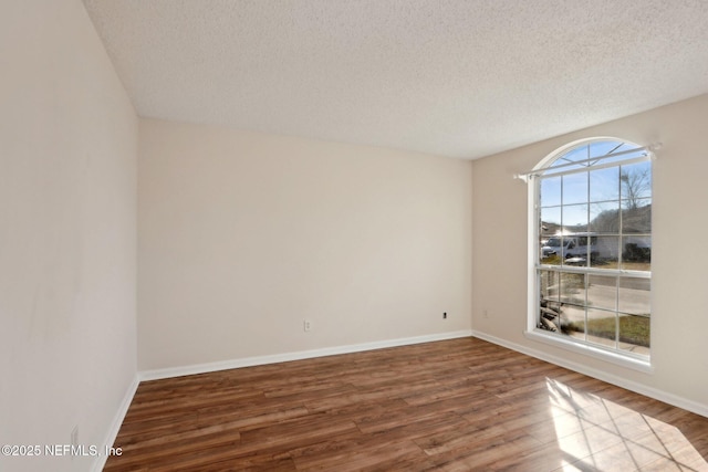 unfurnished room featuring hardwood / wood-style floors and a textured ceiling