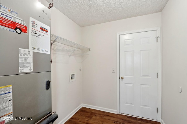 laundry area featuring dark hardwood / wood-style floors, a textured ceiling, hookup for a washing machine, and heating unit