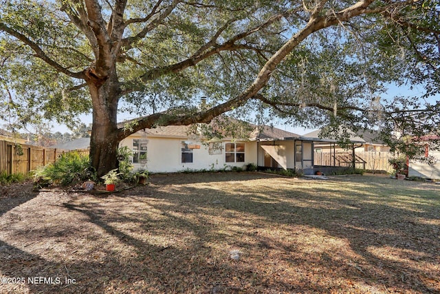 rear view of house featuring a lawn