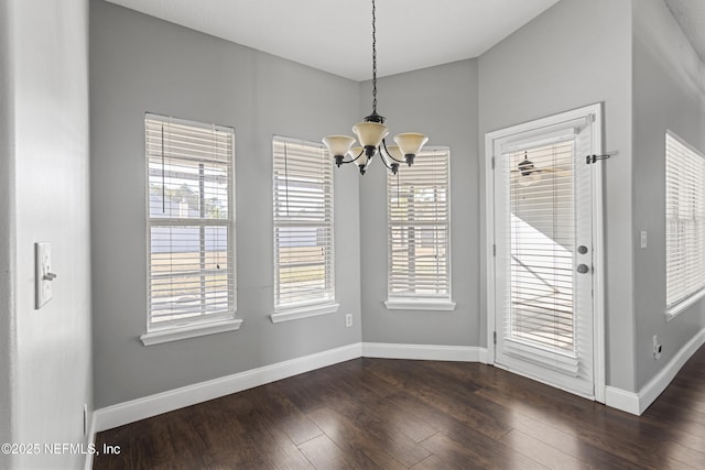 unfurnished dining area featuring a notable chandelier and dark wood-type flooring