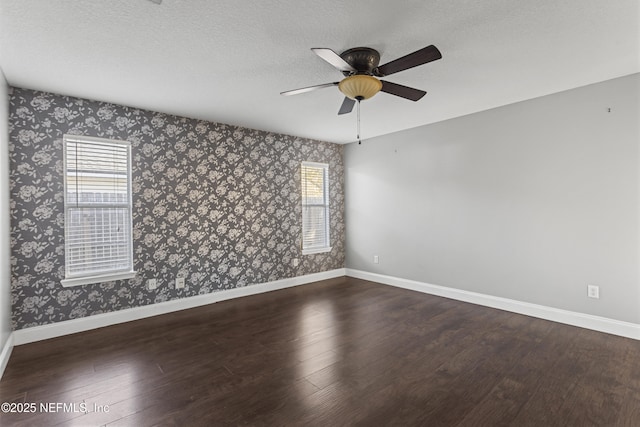 unfurnished room with ceiling fan, dark hardwood / wood-style flooring, and a textured ceiling