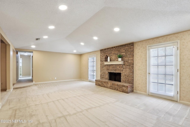 unfurnished living room featuring a healthy amount of sunlight, light carpet, and a fireplace