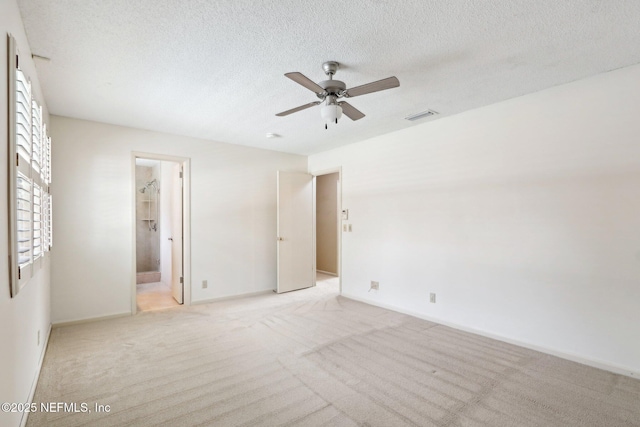 carpeted spare room featuring ceiling fan and a textured ceiling