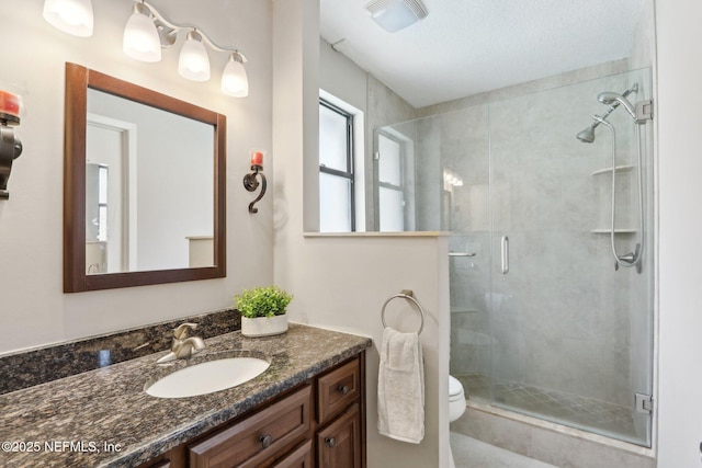 bathroom featuring vanity, toilet, and an enclosed shower