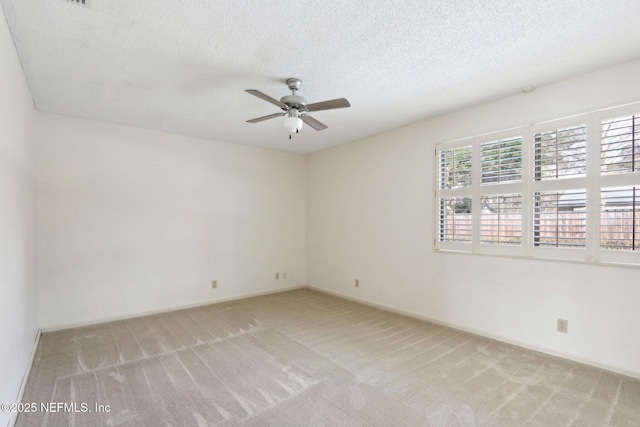 carpeted spare room featuring a textured ceiling and ceiling fan