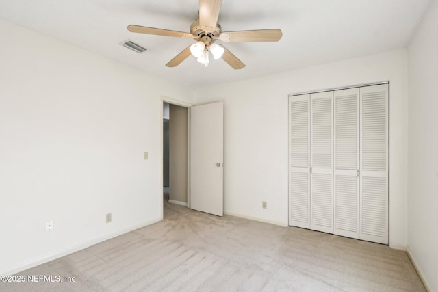 unfurnished bedroom featuring light carpet, a closet, and ceiling fan