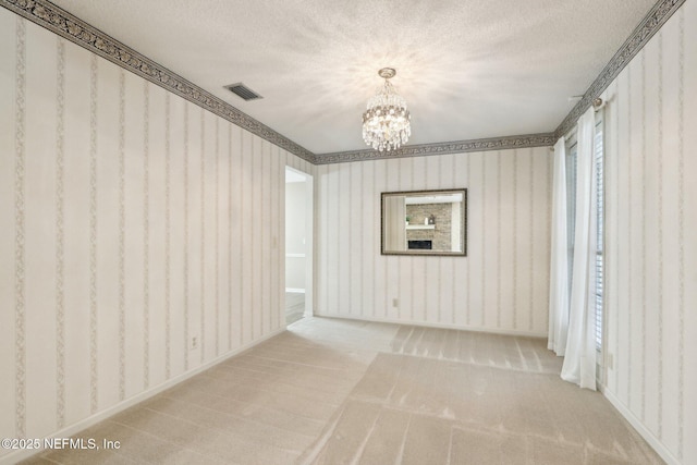 unfurnished room featuring carpet floors, a notable chandelier, and a textured ceiling