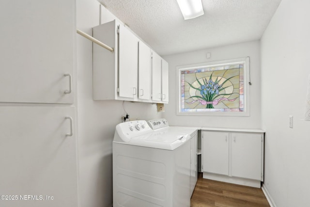 washroom featuring cabinets, dark hardwood / wood-style flooring, washing machine and dryer, and a textured ceiling