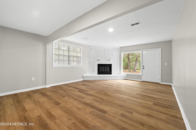 unfurnished living room featuring a fireplace and wood-type flooring