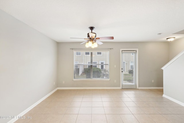 tiled empty room with ceiling fan and a healthy amount of sunlight