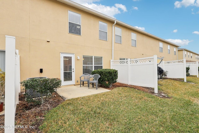 back of property featuring a yard and a patio area