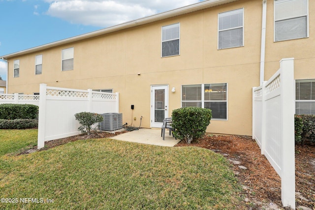 back of property featuring central AC unit, a yard, and a patio