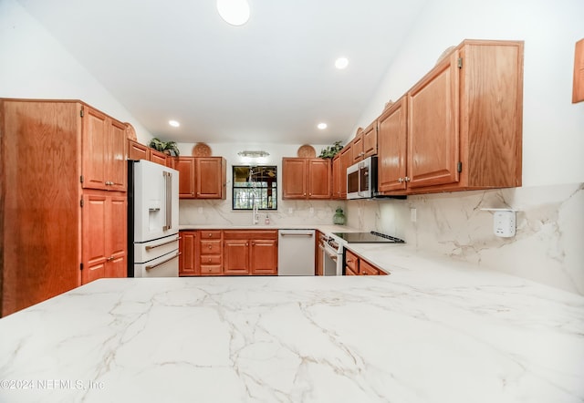 kitchen featuring backsplash, high end appliances, and sink