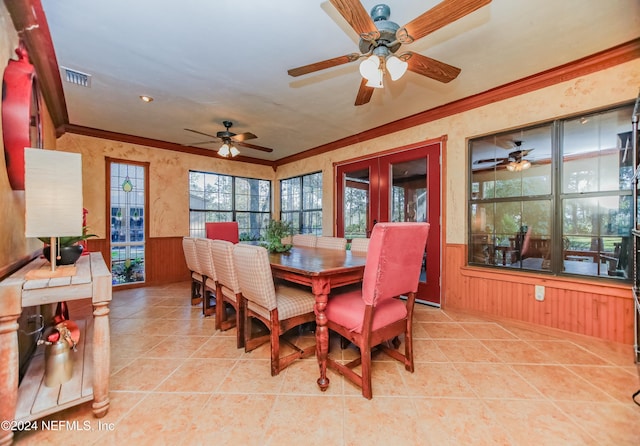 tiled dining room featuring ornamental molding and wood walls