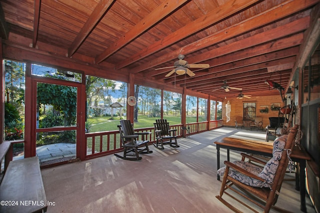 unfurnished sunroom with beamed ceiling and ceiling fan