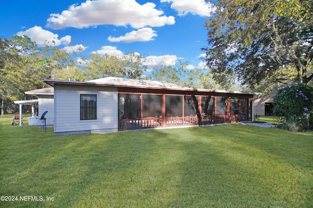 back of property with a lawn and a sunroom