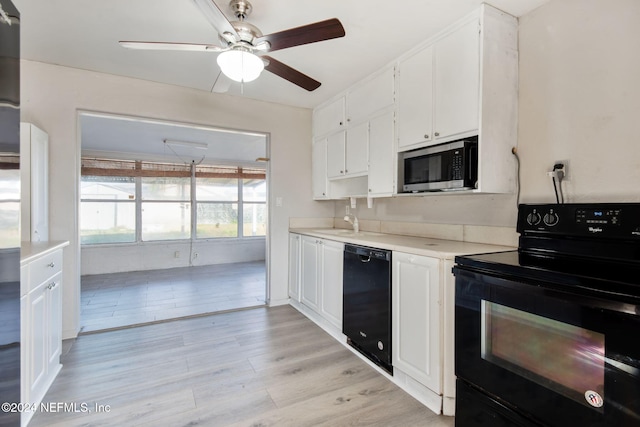 kitchen featuring light wood-type flooring, ceiling fan, sink, black appliances, and white cabinetry