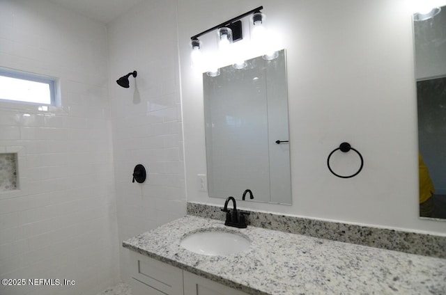 bathroom with vanity and tiled shower